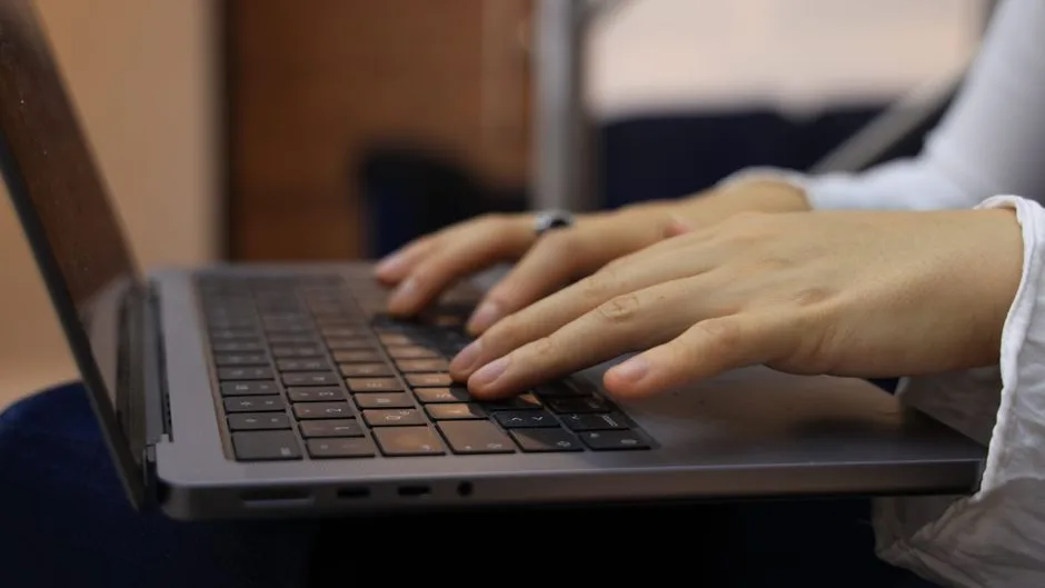 Mains qui écrivent un message sur le clavier d’un ordinateur portable